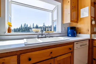 a kitchen with a sink and a window at Riverfront Serenity with Stunning Views in Mariposa
