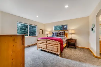 a bedroom with a bed and a dresser and two windows at Chestnut Haus at Tahoe Donner By Tahoe Getaways - 4 BR w HOA Amenities in Truckee
