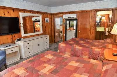 a bedroom with two beds and a flat screen tv at The Kern Lodge in Kernville