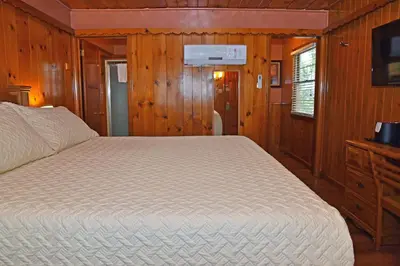 a bedroom with a large bed in a wooden room at The Kern Lodge in Kernville