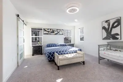 a bedroom with a bed with a blue and white comforter at Spacious 4BR-3BA Cozy and Modern in Elk Grove in Elk Grove