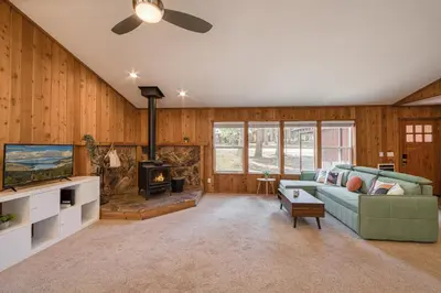 a living room with a couch and a fireplace at Charmed Cabin at Tahoe Donner by Tahoe Getaways - 2BR w HOA Access in Truckee