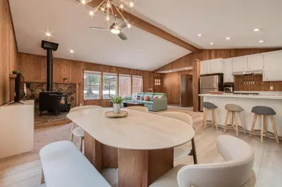 a kitchen and living room with a table and chairs at Charmed Cabin at Tahoe Donner by Tahoe Getaways - 2BR w HOA Access in Truckee