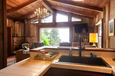 a kitchen with a sink and a large window at Redwoods Oceanview Retreat