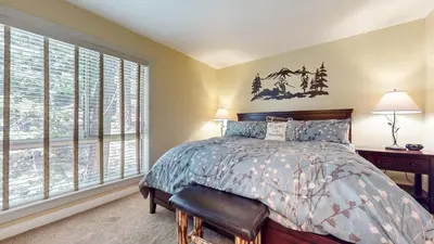 a bedroom with a bed and two windows at Bigwood #30 condo in Mammoth Lakes
