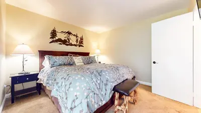 a bedroom with a bed and a chair in it at Bigwood #30 condo in Mammoth Lakes