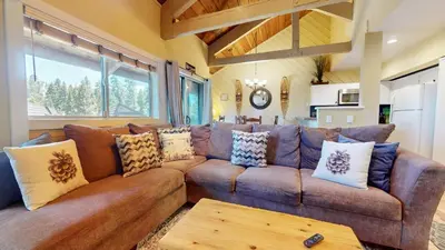 a living room with a brown couch with pillows at Bigwood #30 condo in Mammoth Lakes