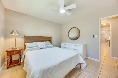 a bedroom with a white bed and a mirror at Shop, Hike and Explore Fresno Home with Private Pool! in Fresno