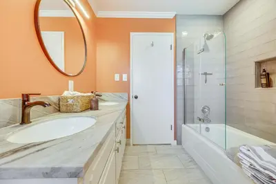 a bathroom with a sink and a tub and a mirror at Shop, Hike and Explore Fresno Home with Private Pool! in Fresno