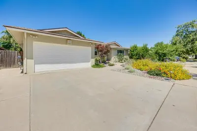 a house with a garage and a driveway at Shop, Hike and Explore Fresno Home with Private Pool! in Fresno