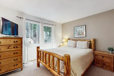 a bedroom with a bed and a tv and a dresser at The Bear's Den in South Lake Tahoe