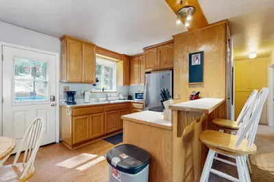 a kitchen with wooden cabinets and a table and chairs at The Bear's Den in South Lake Tahoe