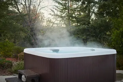 a hot tub with steam in a garden at Scenic Mountain Views w Heated Pool, Game Room, and Hottubs in Oakhurst