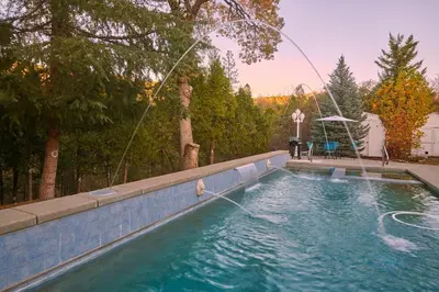 a swimming pool with a water hose at Scenic Mountain Views w Heated Pool, Game Room, and Hottubs in Oakhurst