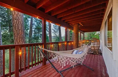a hammock on the porch of a house at Yosemite family getaway w lake, golf, horses, pool in Groveland