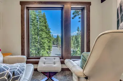 a living room with two chairs and a large window at Agate Bay Getaway with Lake Views in Carnelian Bay