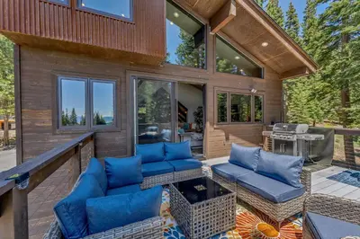 a screened in porch with blue furniture on a deck at Agate Bay Getaway with Lake Views in Carnelian Bay