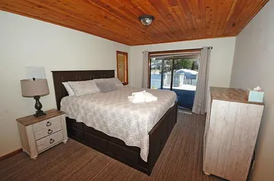 a bedroom with a bed with a wooden ceiling at 625 Alpine Drive home in South Lake Tahoe
