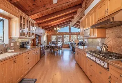 a large kitchen with wooden cabinets and a table at 625 Alpine Drive home in South Lake Tahoe