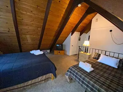 a attic room with two beds and a television at 2708 Springwood Drive cabin in South Lake Tahoe