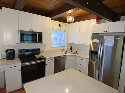 a kitchen with white cabinets and stainless steel appliances at 2708 Springwood Drive cabin in South Lake Tahoe