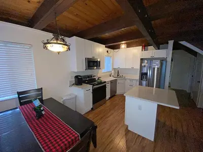 a kitchen with white cabinets and a table with a red checkered sidx sidx at 2708 Springwood Drive cabin in South Lake Tahoe