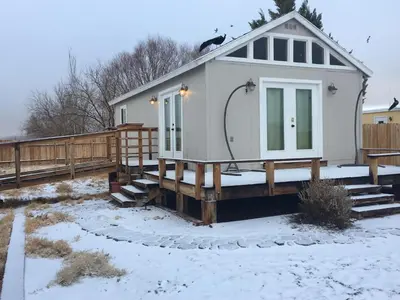 a small white house with snow on the ground at Shady Lady Bed and Breakfast in Scottys Junction