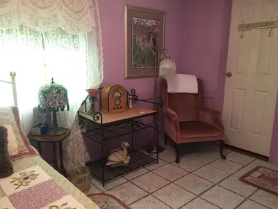 a room with a bed and a chair and a table at Shady Lady Bed and Breakfast in Scottys Junction