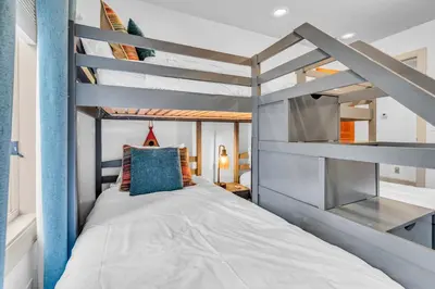 a small bedroom with a bunk bed with blue walls at Homewood Hideaway Family Friendly plus EV Charger in Homewood