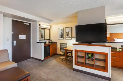 a hotel room with a television and a living room at Hyatt Place Sacramento Roseville in Roseville