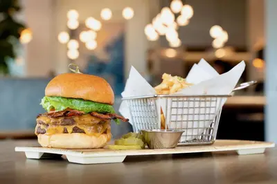 a sandwich and two baskets of fries on a table at Hyatt Place Sacramento Roseville in Roseville