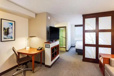 a hotel room with a desk and a television at Hyatt Place Sacramento Roseville in Roseville