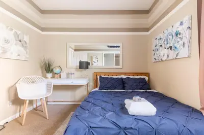 a bedroom with a blue bed and a desk at Rose Garden in Sacramento