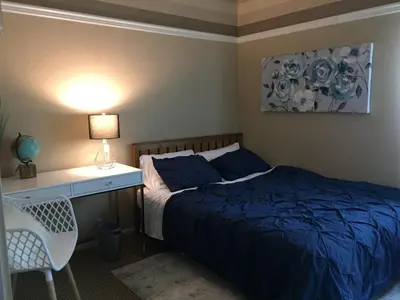 a bedroom with a bed and a desk with a lamp at Rose Garden in Sacramento