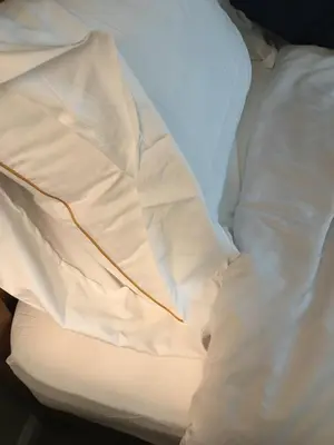 an unmade bed with white sheets and pillows at Rose Garden in Sacramento