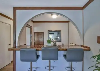 a room with a counter with three chairs and a mirror at 2148 Inverness Drive home in South Lake Tahoe