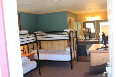 a room with two bunk beds and a bathroom at Whitney Portal Hotel And Hostel in Lone Pine