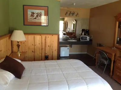 a bedroom with a large white bed and a desk at Whitney Portal Hotel And Hostel in Lone Pine