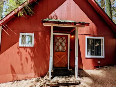 a red barn with a red door and two windows at Meadow View Cabin in Wilsonia in Wilsonia