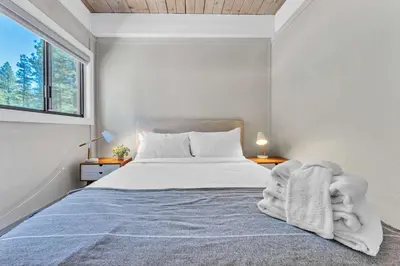 a bedroom with a bed with a blanket and a window at Modern Incline Village Escape Near Lake and Trails in Incline Village