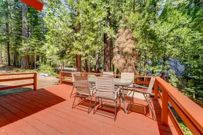 a wooden deck with a table and chairs on it at Hike and Ski! Cabin 20 Mi to Soda Springs Mtn Resort in Emigrant Gap
