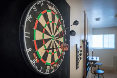 a dart board with a persons hand in front of it at The Deco Retreat - UNR - Pet Friendly in Reno