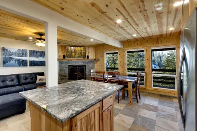 a kitchen and living room with a couch and a fireplace at Tall Pine Chalet home in Stateline