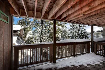 a view from the porch of a cabin with snow covered trees at Snowflake Chalet condo in Stateline
