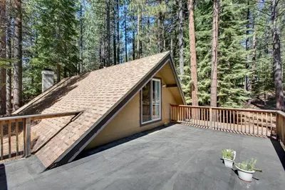 a small house with a deck in the woods at Sagebrush Cottage chalet in South Lake Tahoe