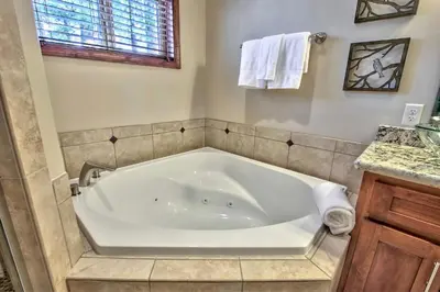 a white bath tub in a bathroom with a sink at Conifer Chalet condo in South Lake Tahoe
