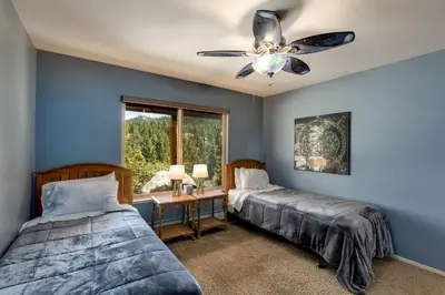 a bedroom with two beds and a ceiling fan at Tudor Lodge home in Stateline