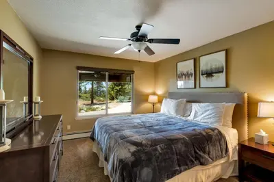 a bedroom with a bed and a ceiling fan at Tudor Lodge home in Stateline