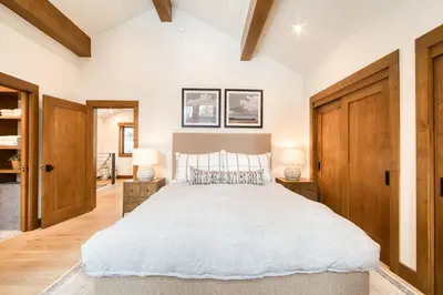 a bedroom with a large bed and wooden doors at Splendid at Chamberlands by Tahoe Getaways - Chamberlands HOA, Private Hot Tub & Walk to Lake Tahoe in Tahoma