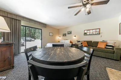 a living room with a table and a bedroom at Beautiful Studio W/Kitchenette #134 at Donner Lake Village in Truckee